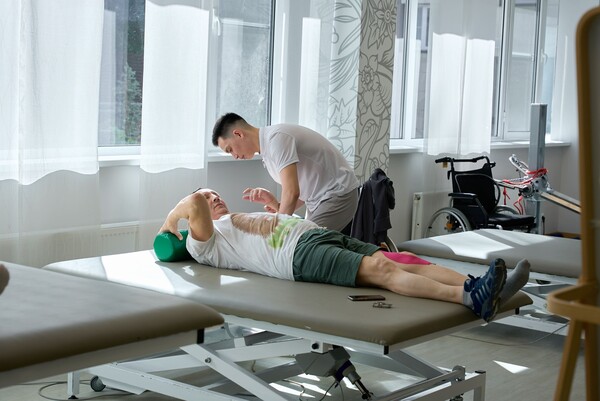 Пациент с физическим терапевтом в зале физической терапии