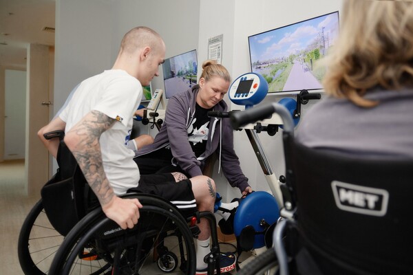 Пациенты занимаются на тренажёре под контролем физического терапевта