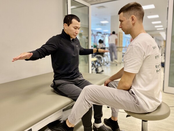 Пациент выполняет упражнение на баланс с физическим терапевтом