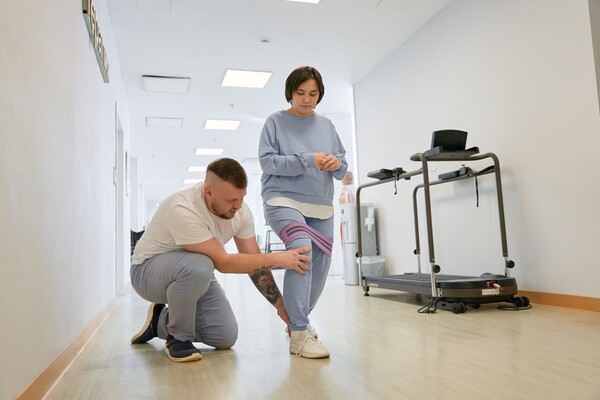 Пациентка под контролем физического терапевта выполняет упражнения на улучшение баланса, чувства опоры, контроля движений
